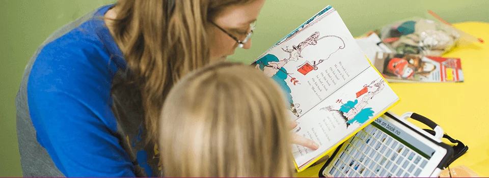 A therapist working with a child on a picture activity