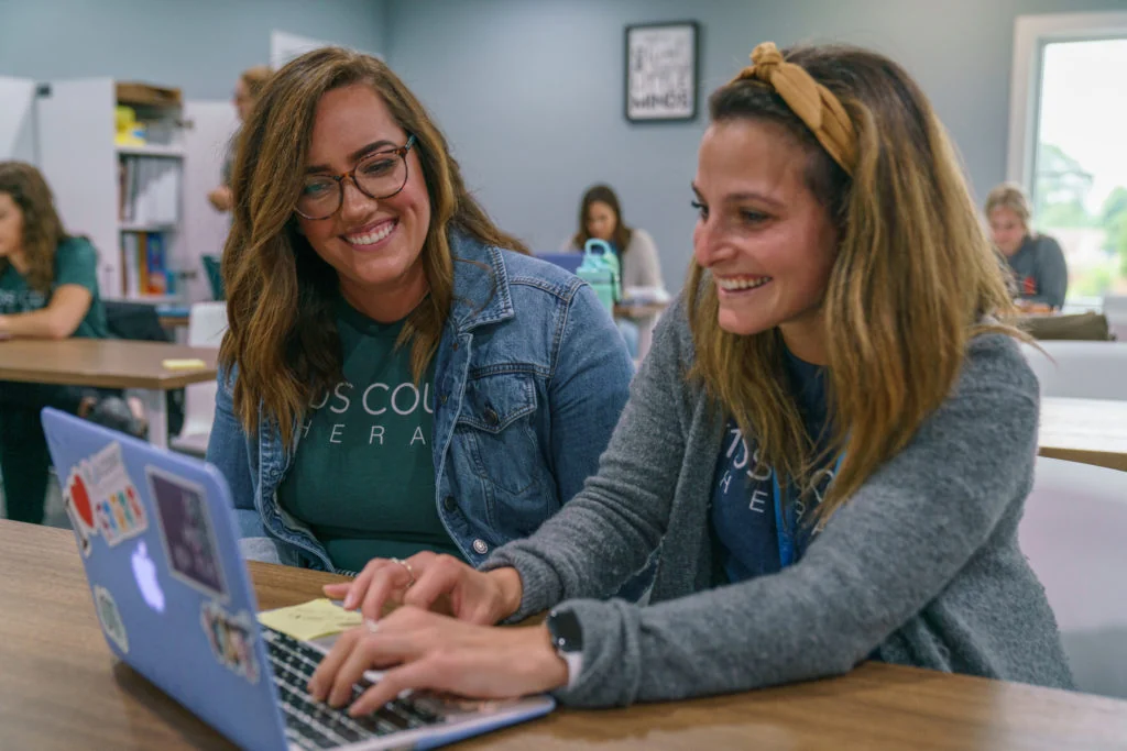 Two K1ds Count Therapy team members smiling at a laptop