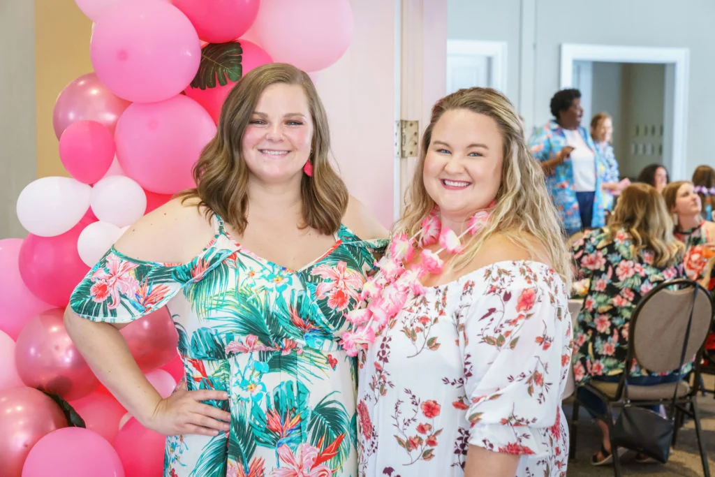 Team members at a celebration with pink balloons